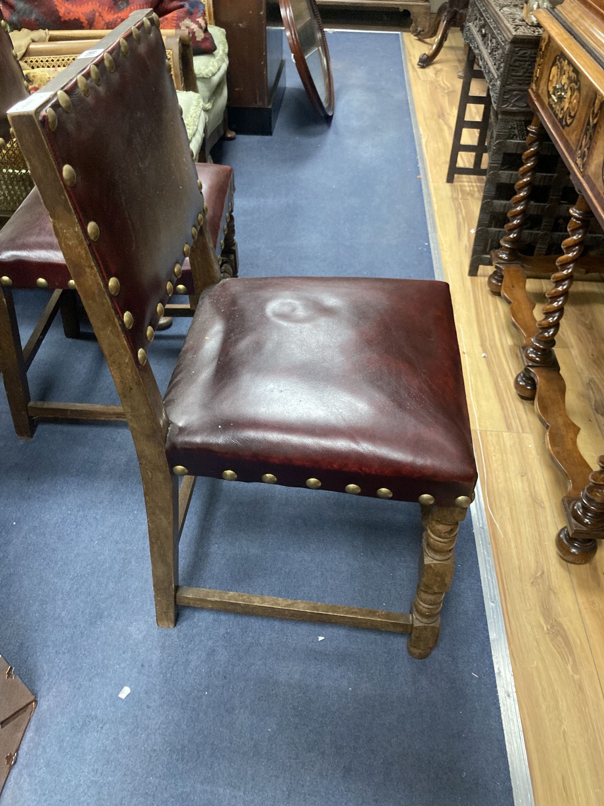 A pair of oak carolean-style dining chairs circa 1880, red leather and studding